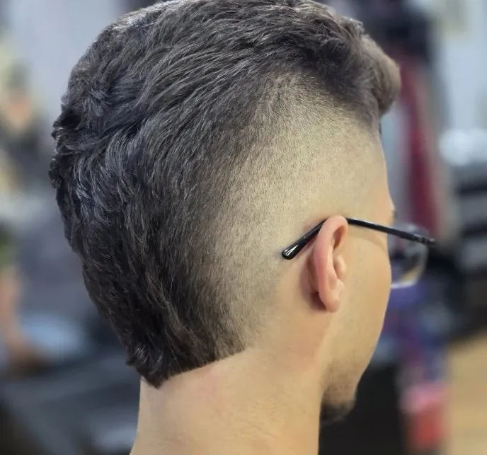 Vista de trás de um mullet com degradê navalhado ao redor da orelha